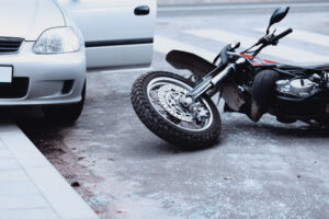 Motorcycle automobile accident with cycle on the ground